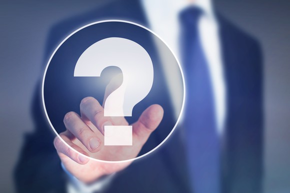 A businessman points to a question mark.