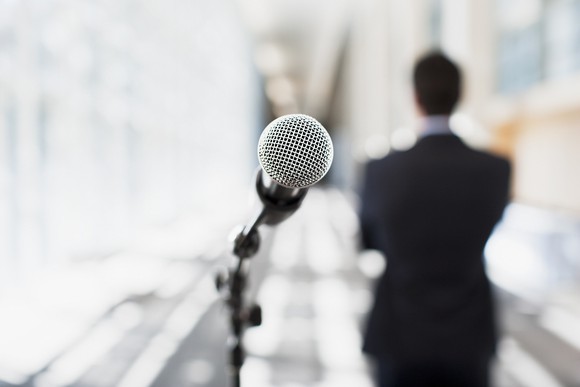A microphone is viewed from the perspective of the speaker.