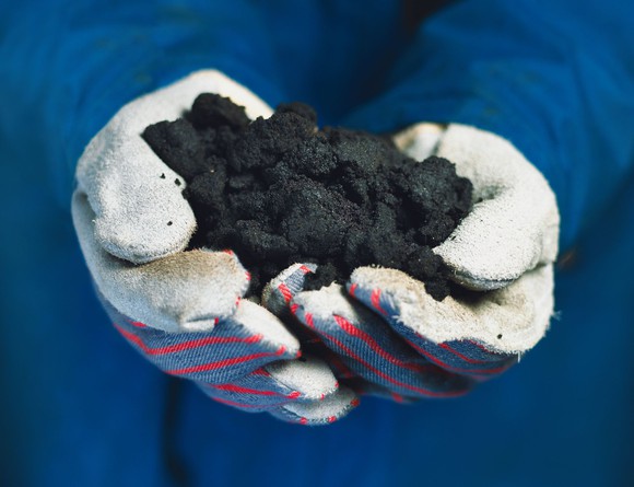 Bitumen held by white gloves.