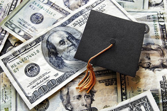 A graduation cap on top of $100 bills