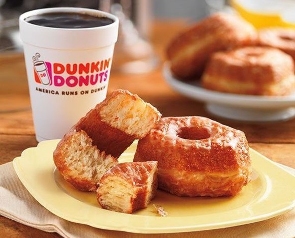 Steaming coffee and croissant-doughnut.
