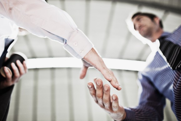 Two business people shake hands after coming to an agreement.