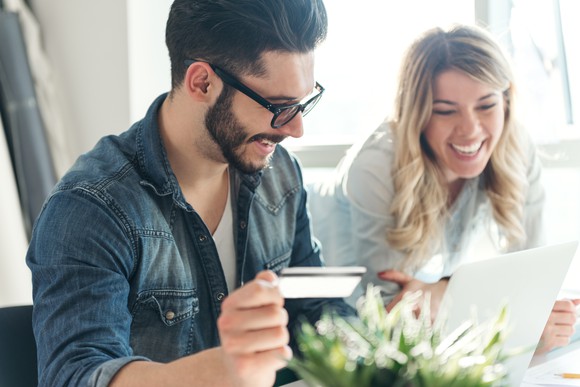 Couple using a credit card to shop online.