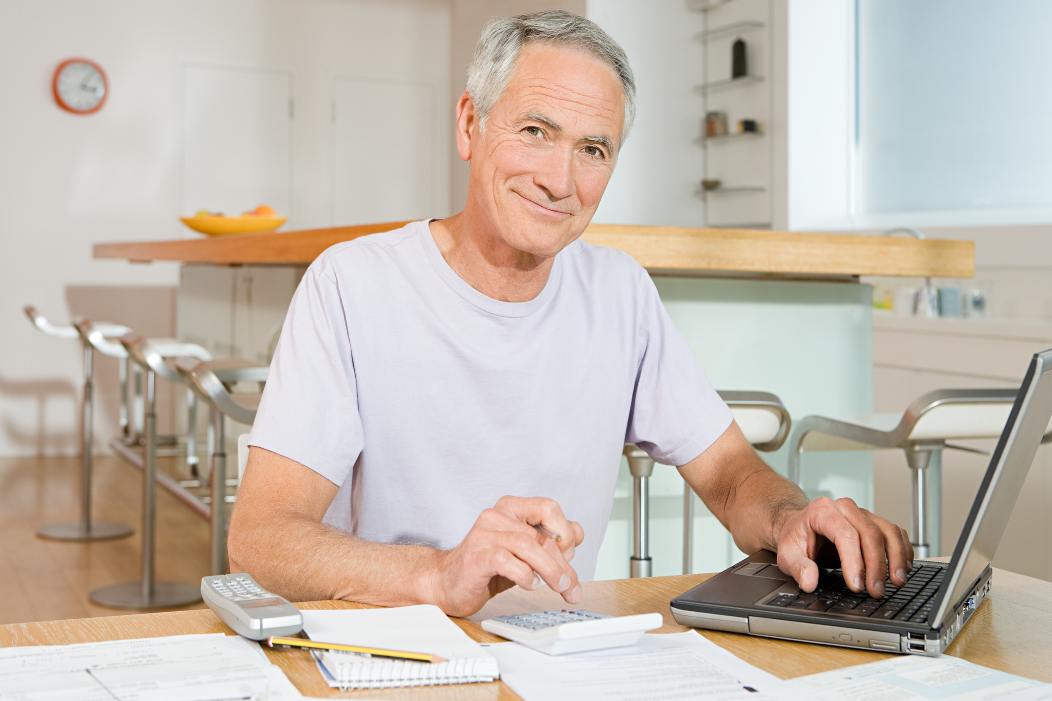 A senior man calculating his Social Security benefit and examining his finances.