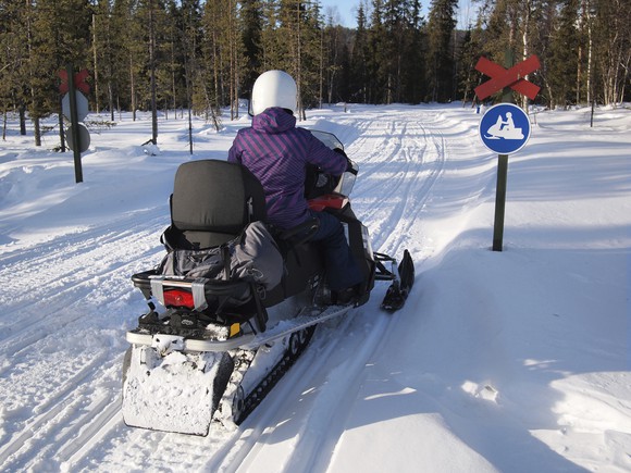 Snowmobiler facing no snowmobiles sign.