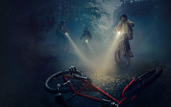 Banner for the show "Stranger Things," with flashlights through the mist
