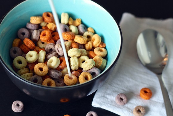 A bowl of cereal with milk being poured into it.