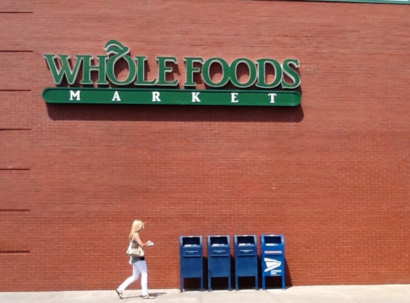 A sign on an outside wall of a Whole Foods