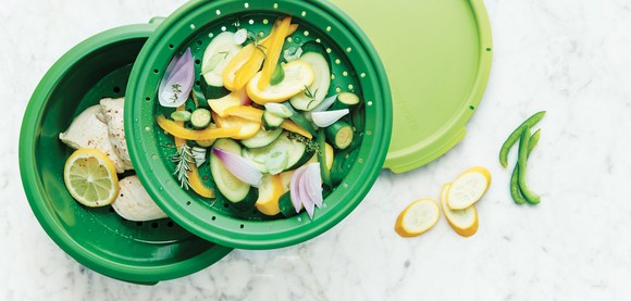 Green plastic food storage containers holding salad.