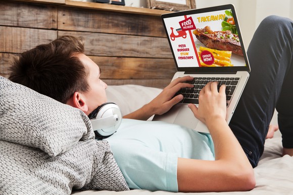 A man orders takeout on his laptop.