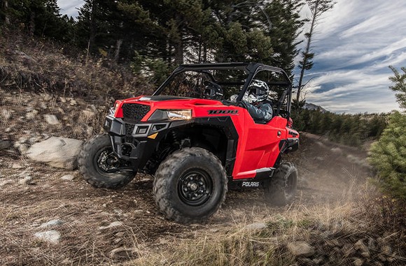 A red Polaris Industries General 1000 UTV on a rocky dirt road