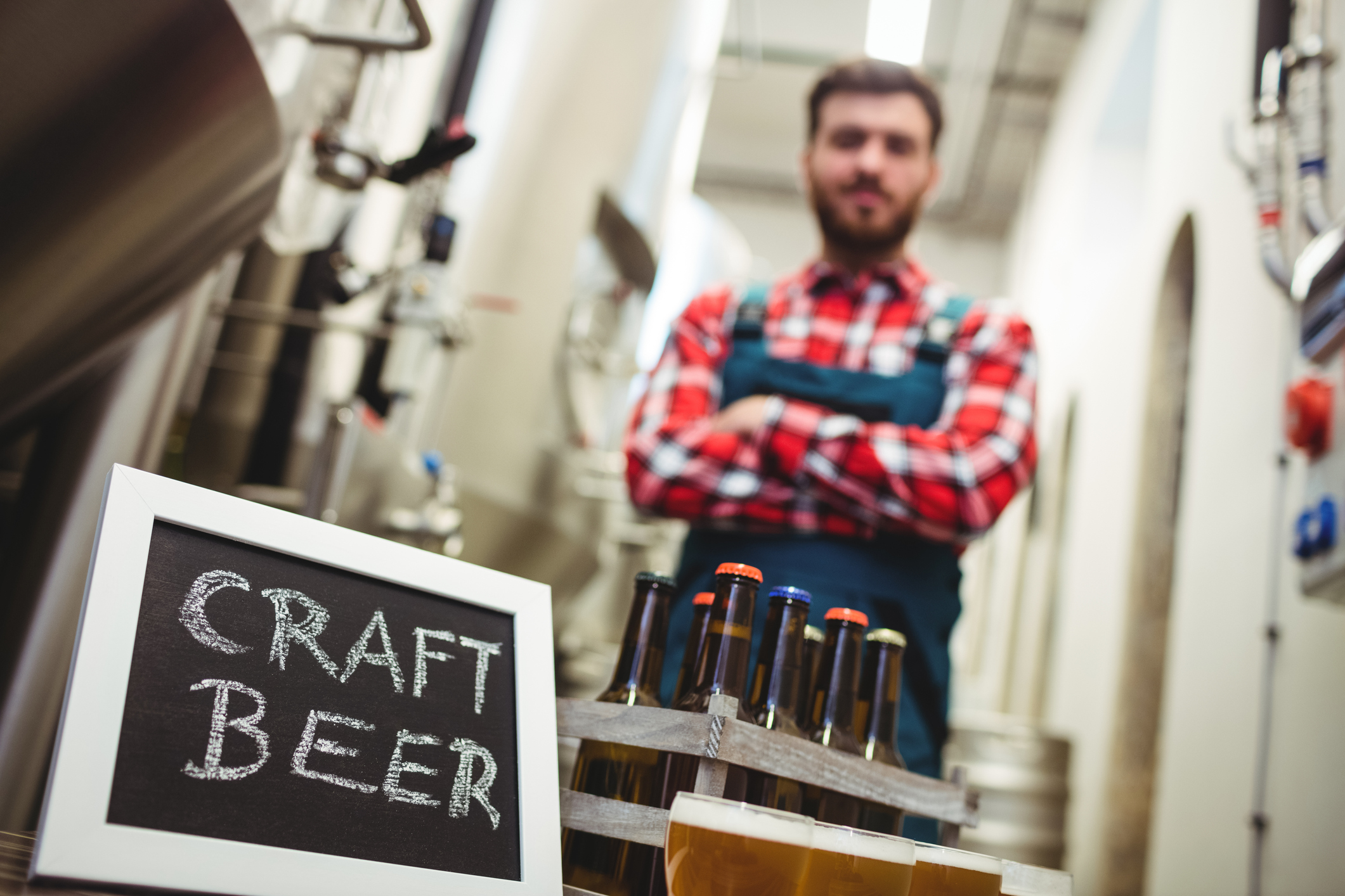 Craft beer brewer in front of a sign stating craft beer and a selection of brews