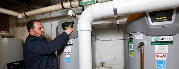 Man installing commercial water heating system