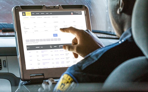 Police officer entering data into Axon's Evidence.com database