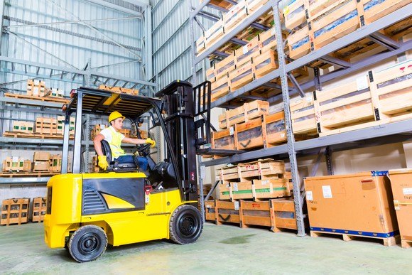 Forklift in a warehouse picking boxes.