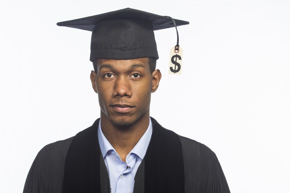 Graduate wearing mortarboard with a dollar sign in place of a tassel