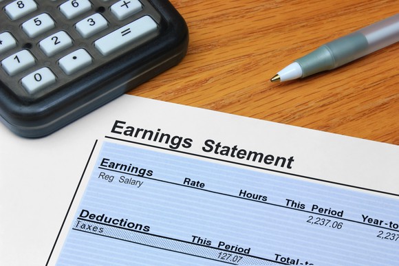 paycheck and calculator on a table