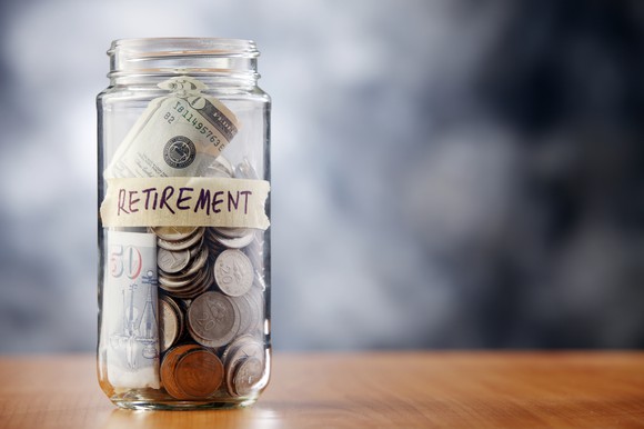 Glass jar with cash in it, labeled "retirement"