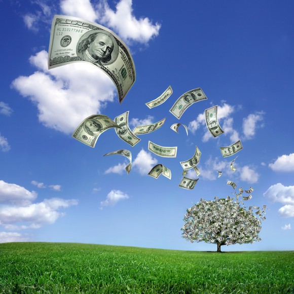 Dollar bills fall from a money tree.
