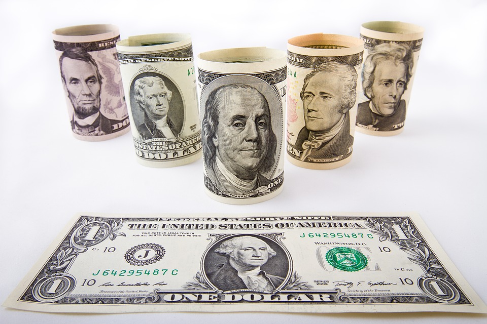 Rolled denominations of money on a table.