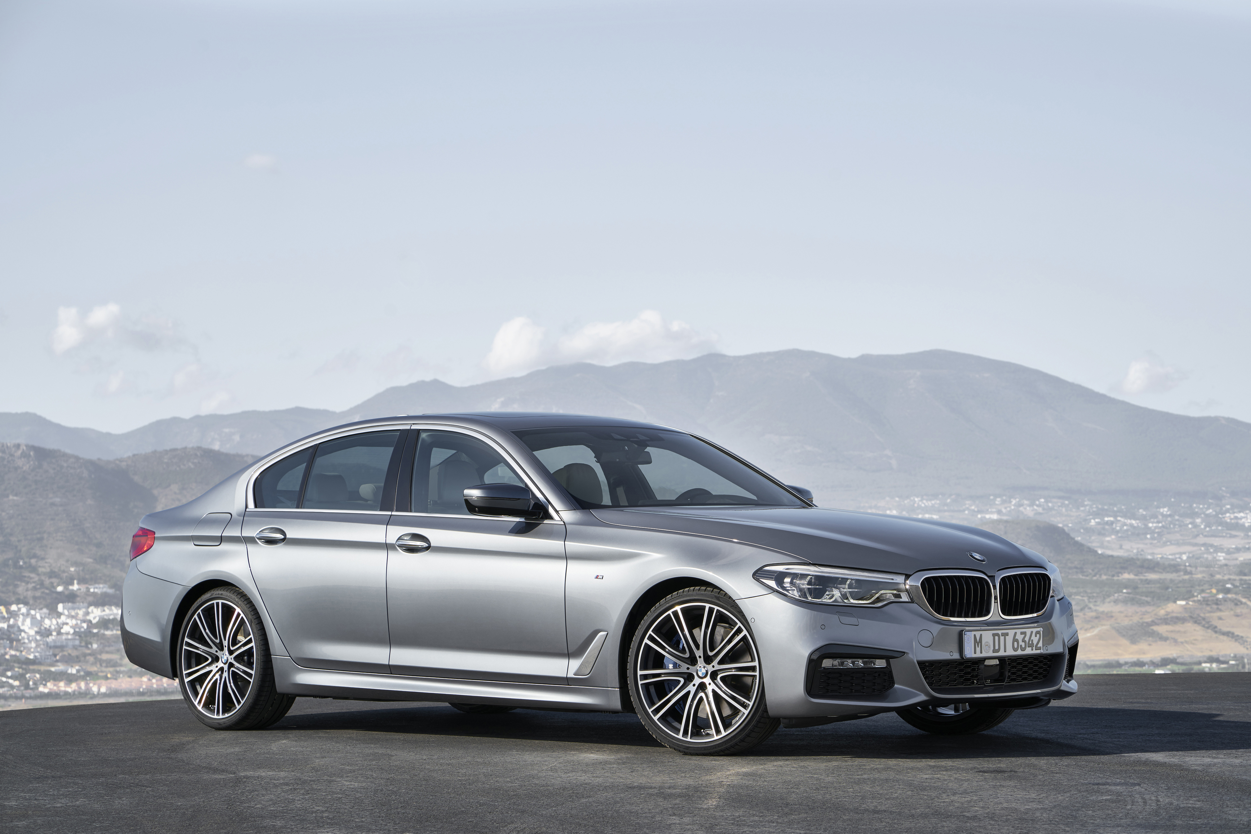 A silver BMW 5 Series sedan.