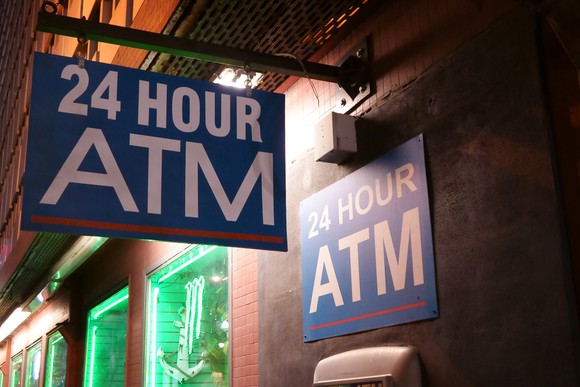 A sign for a 24 hour ATM.