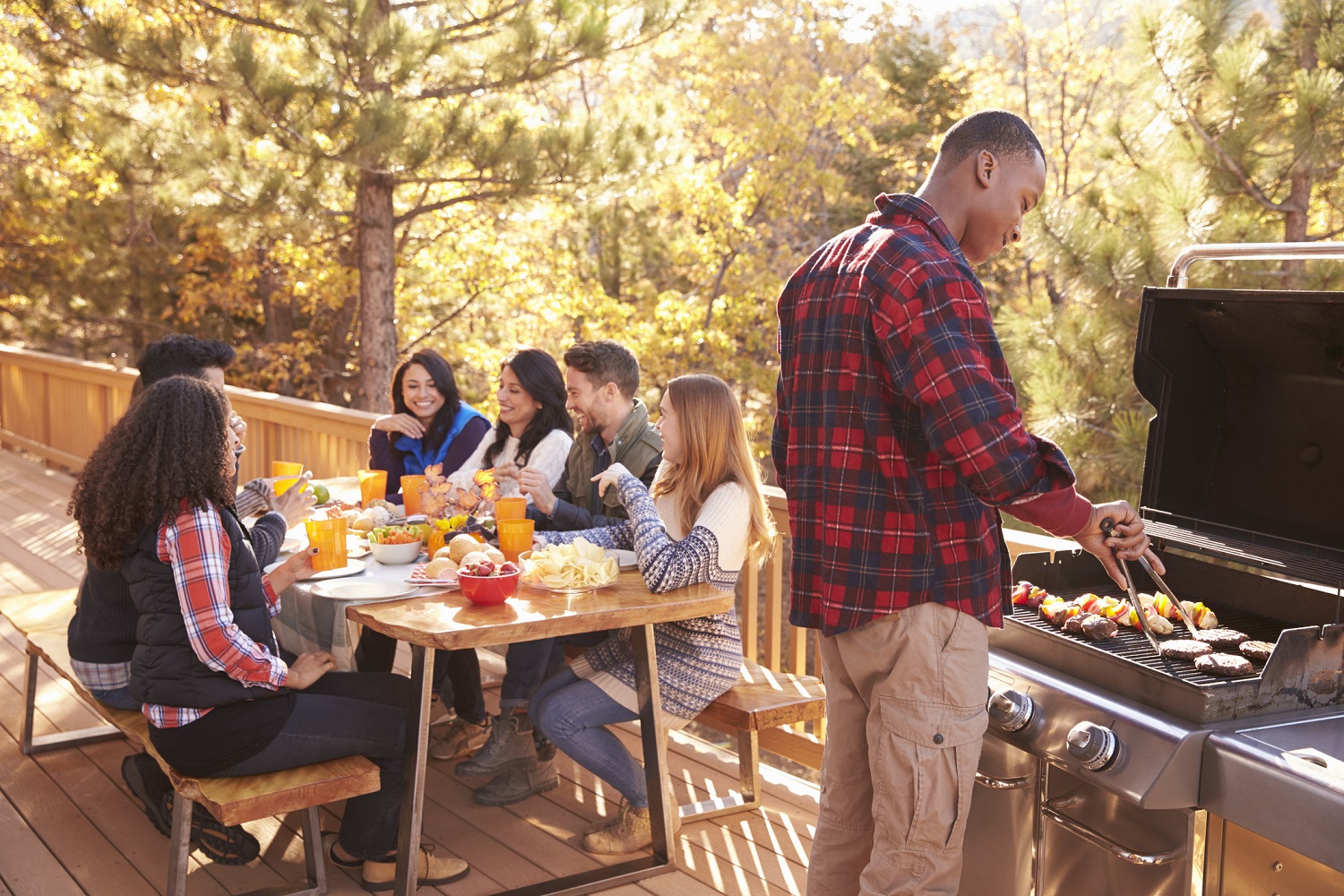 Friends gather for a cookout on a deck.