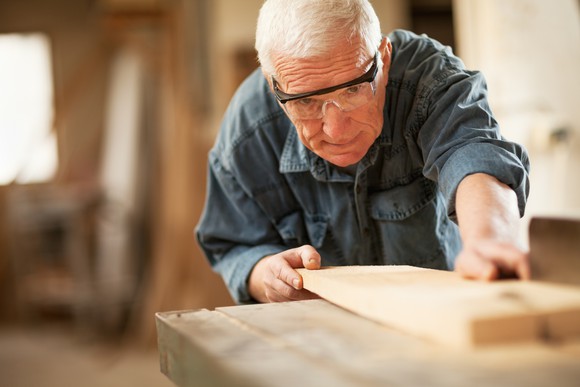 A senior citizen working in a lumber store.