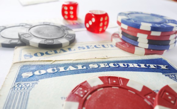A Social Security card flanked by gambling chips and dice.