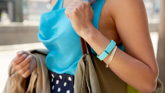 A woman wearing a Fitbit bracelet.