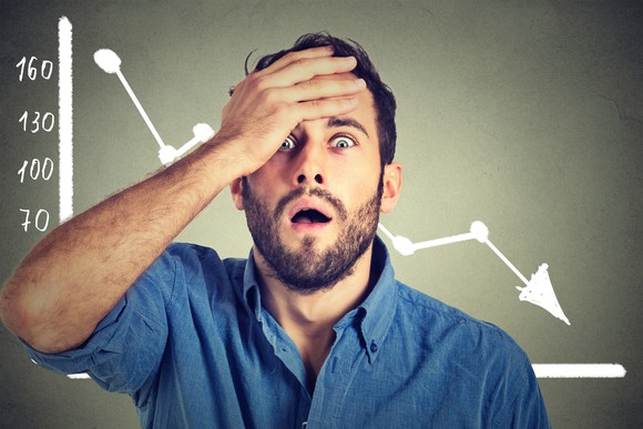 Frustrated person in front of downward-sloping stock chart