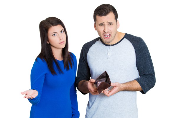 A young couple showing off an empty wallet.
