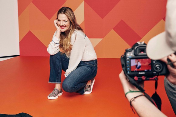 Crocs ambassador Drew Barrymore being photographed wearing a pair of Crocs.