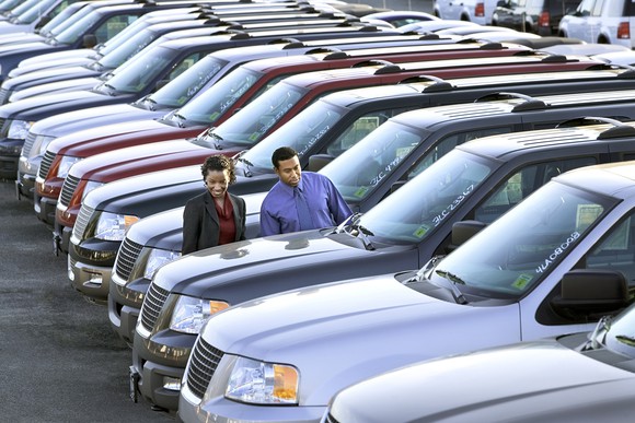 Couple shopping for an SUV at dealership.