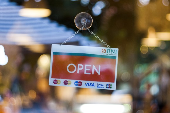 An open sign hangs on a retail store.