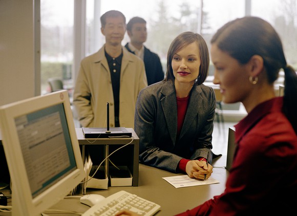 A bank teller helping customers.