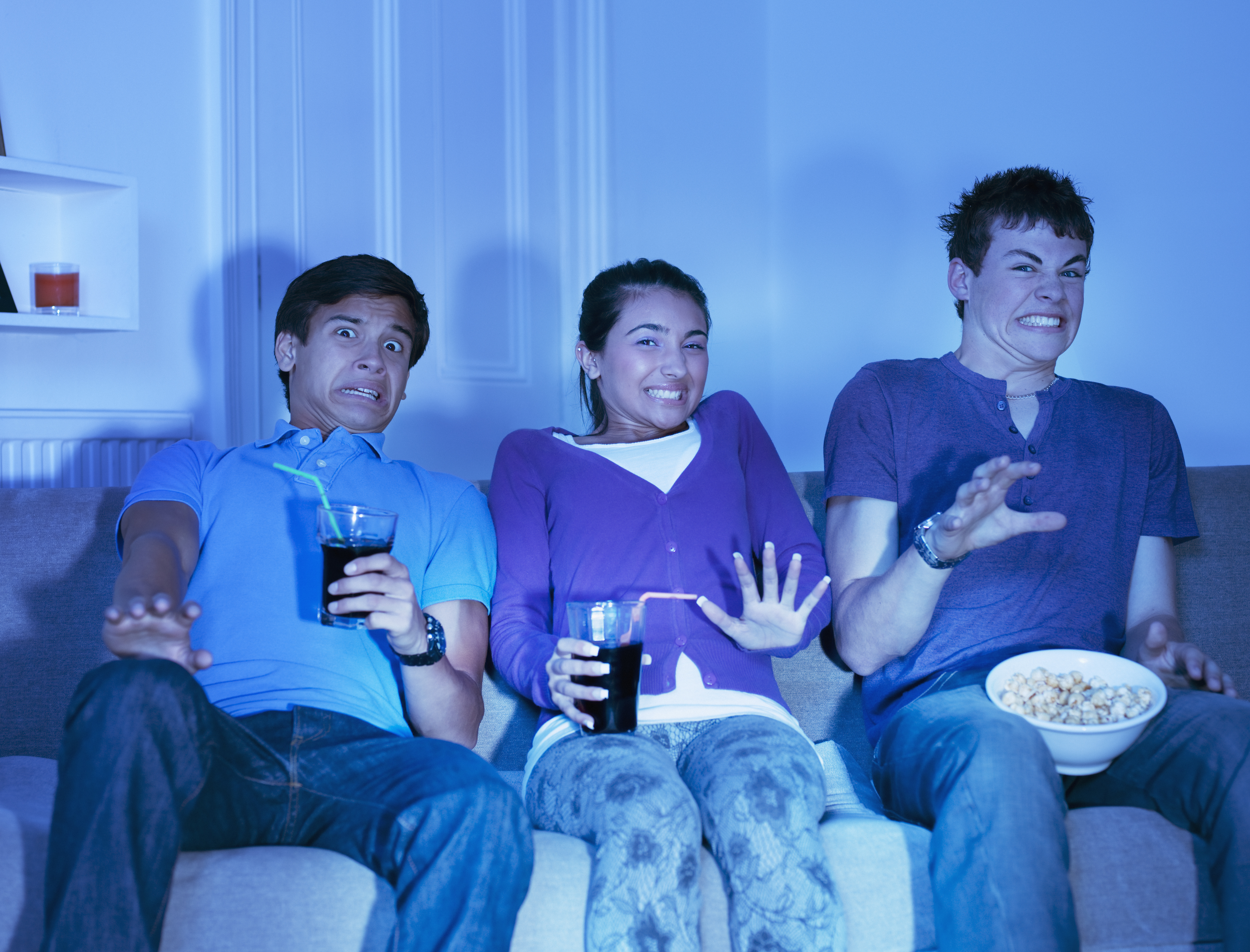 Several teens stream content from the sofa at home.