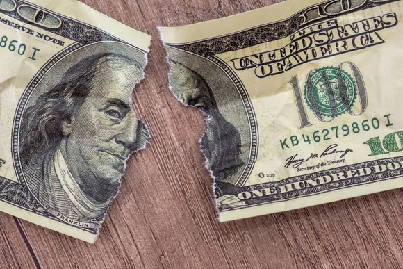 100 dollar bill torn in half.