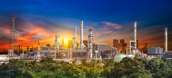 Oil refinery shown with a multi colored sky.