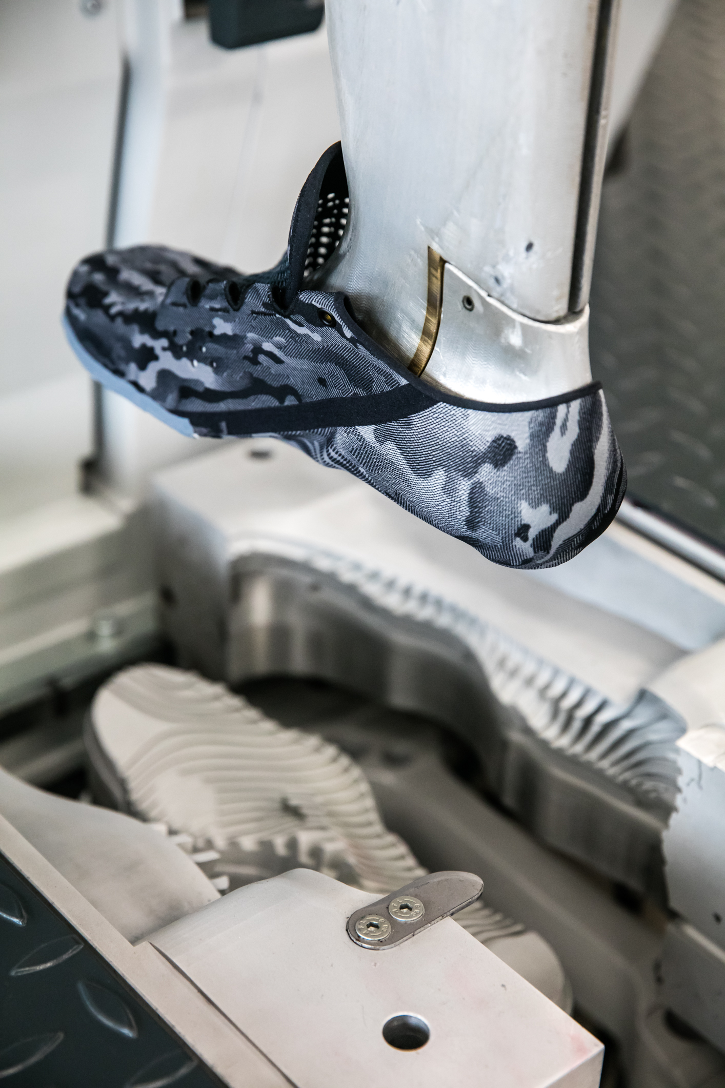 A piece of machinery making an Under Armour shoe.