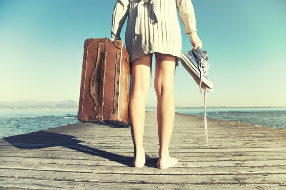Woman standing on dock with suitcase