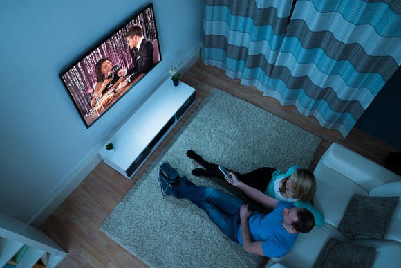 Couple watching television in living room