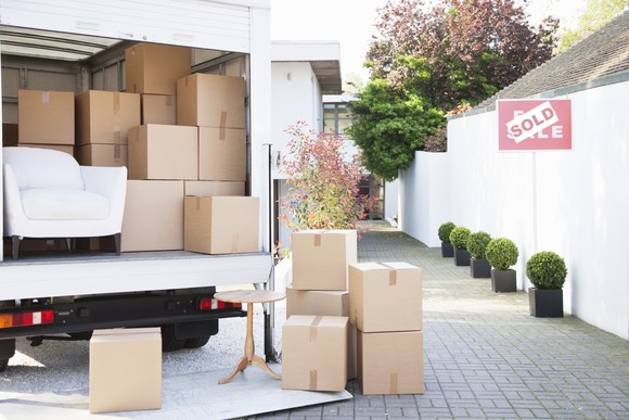 A moving truck is being loaded with boxes.