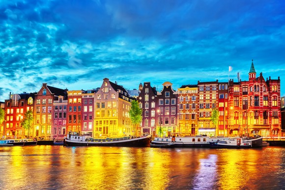 An illuminated Amsterdam skyline at night.