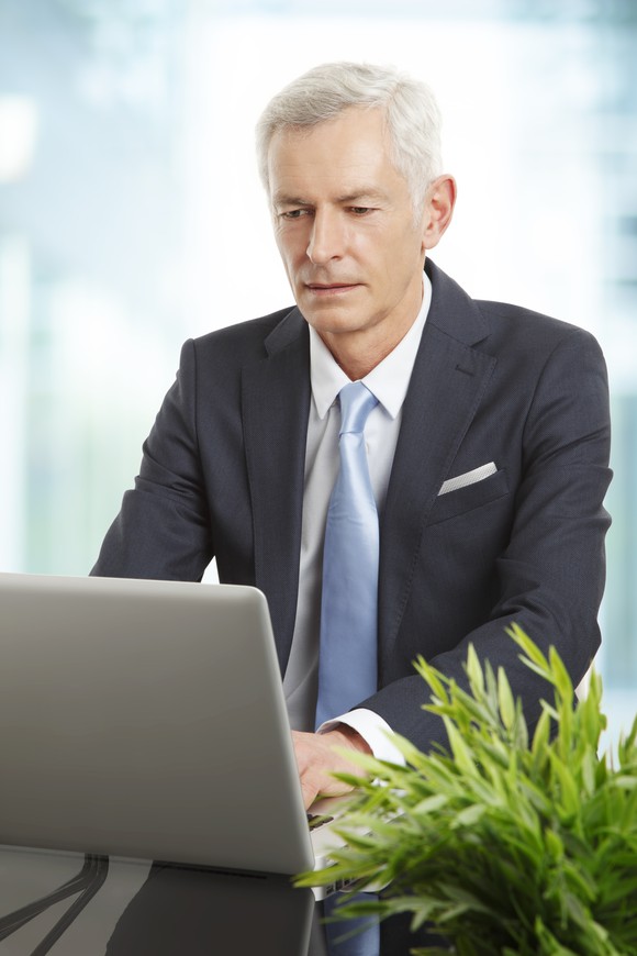Professional man in a suit and tie on a laptop.