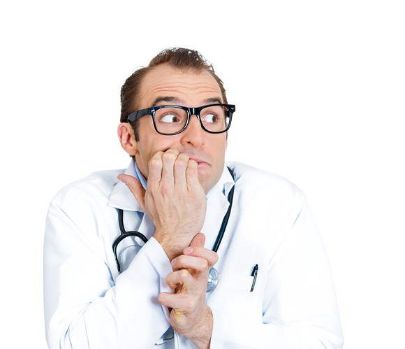A worried doctor biting his nails.