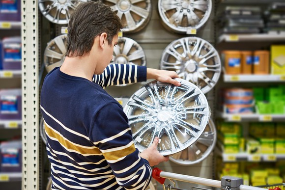 A man shops for hub caps in an auto parts store.