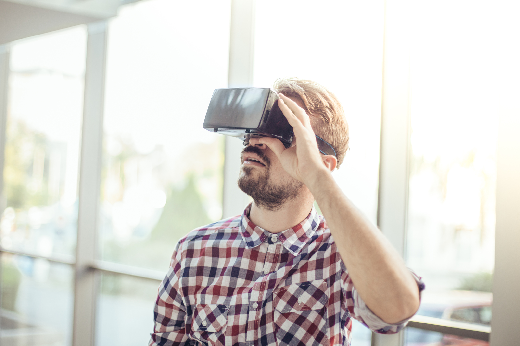 A young man uses a virtual reality headset.