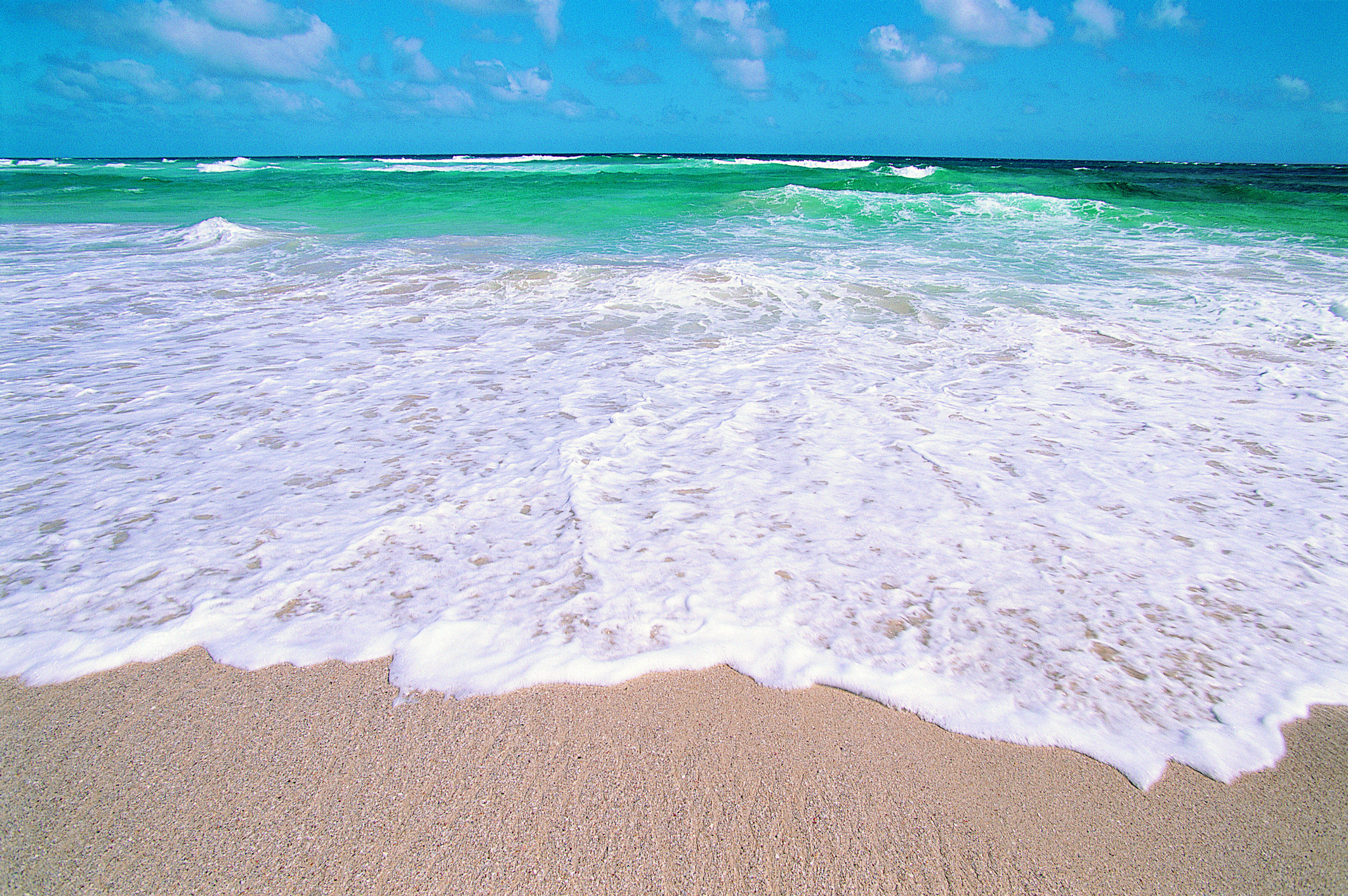 A wave washes up onto the beach.