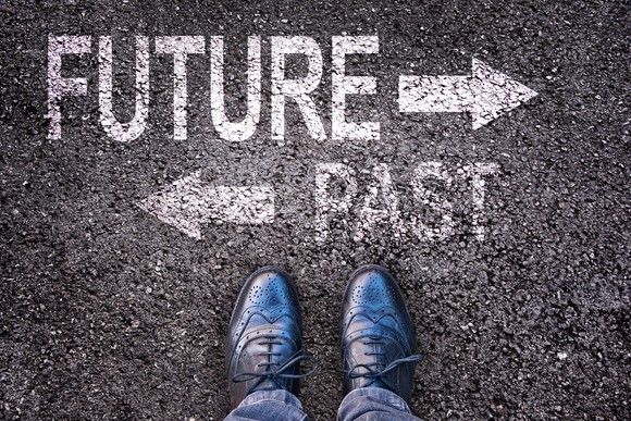 One arrow points to the future, while one points the opposite directions to the past, with feet perpendicular.